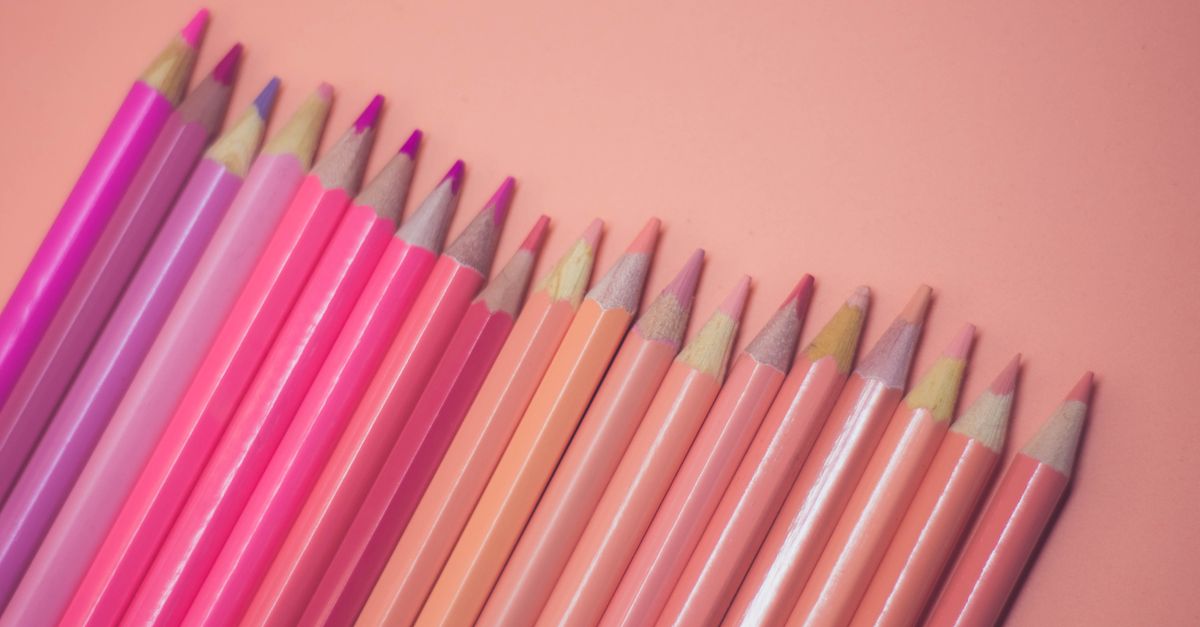 A collection of pink and pastel colored pencils laid on a soft pink background, offering a creative and artistic vibe.